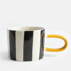 Krus med sort-hvide striber og gul hank – grafisk stentøjskop i moderne design