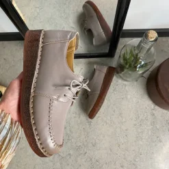 Sandfarvet snøresko i læder med god stødabsorbering.